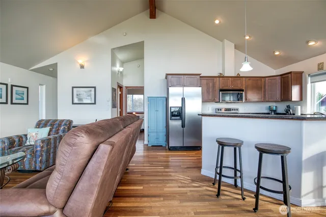 a large kitchen with stainless steel appliances kitchen island granite countertop a refrigerator a stove a sink a table and chairs