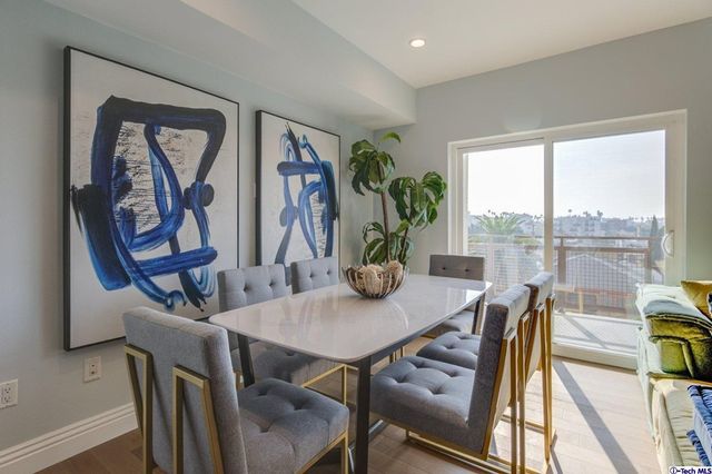 a bedroom with a bed a chair and potted plant on the dresser