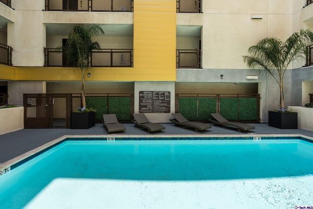 a view of an house with swimming pool and sitting area