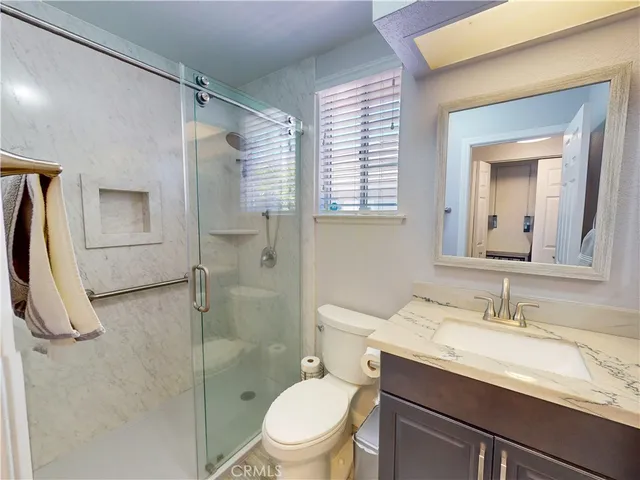 a bathroom with a granite countertop sink toilet and shower