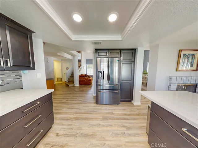 a kitchen with stainless steel appliances kitchen island granite countertop a refrigerator and a sink