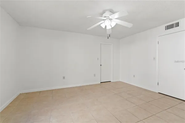 an empty room with a chandelier fan
