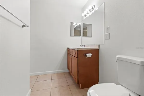 a bathroom with a granite countertop toilet and a sink