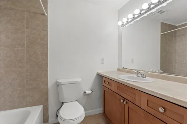a bathroom with a granite countertop toilet sink and mirror