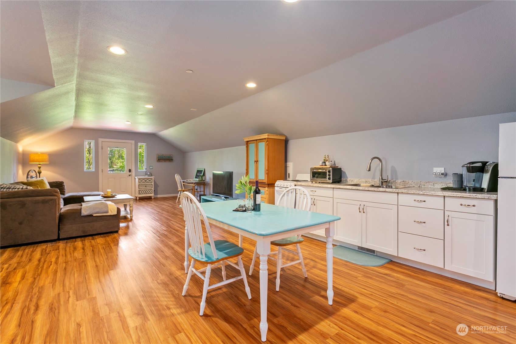 6082 Old Guide Road Bellingham, WA 98226 - Photo 27 of 39 a kitchen with stainless steel appliances kitchen island granite countertop a stove a sink dishwasher and white cabinets with wooden floor