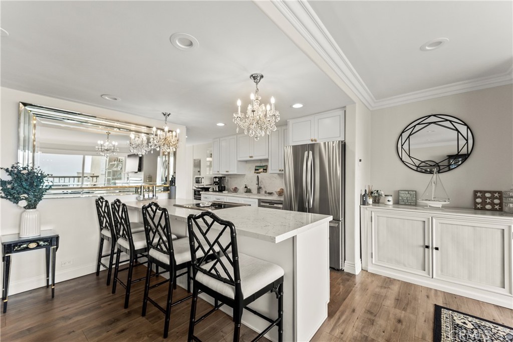 23920 De Ville Way, Unit D Malibu, CA 90265 - Photo 11 of 42 a kitchen with kitchen island granite countertop a dining table chairs cabinets and stainless steel appliances