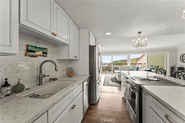 a kitchen with kitchen island granite countertop a sink stainless steel appliances and cabinets
