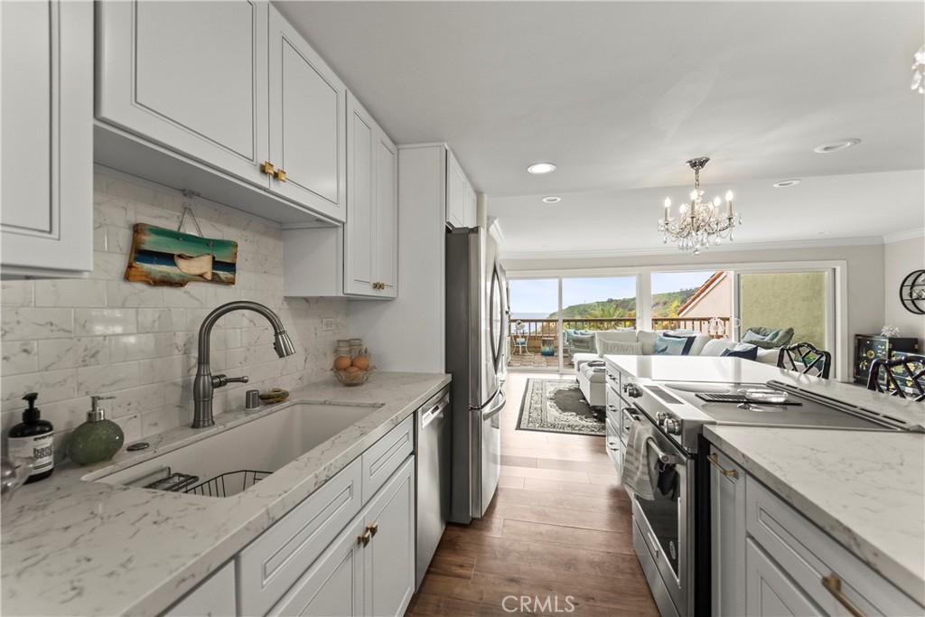 23920 De Ville Way, Unit D Malibu, CA 90265 - Photo 12 of 42 a kitchen with kitchen island granite countertop a sink stainless steel appliances and cabinets