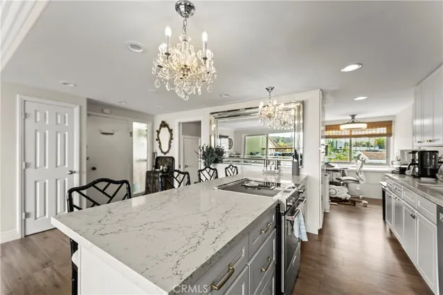 a view of a dining room with furniture a chandelier and wooden floor
