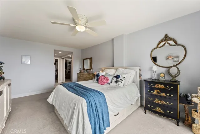 a bedroom with a bed a chandelier and a dresser