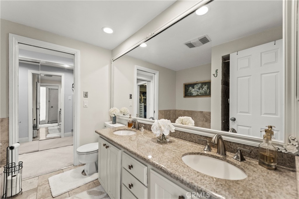 23920 De Ville Way, Unit D Malibu, CA 90265 - Photo 28 of 42 a bathroom with a granite countertop double vanity sink a mirror and a toilet