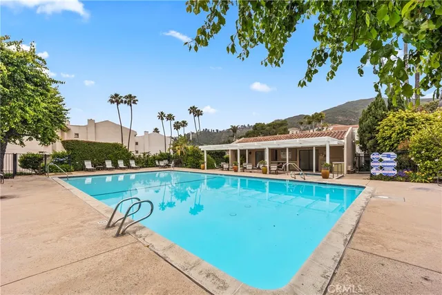 a view of a house with pool and a yard