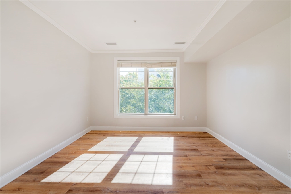 248 Albion Street, Unit 321 Wakefield, MA 01880 - Photo 15 of 19 an empty room with wooden floor and windows
