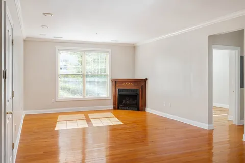 a view of an empty room with window and a kitchen