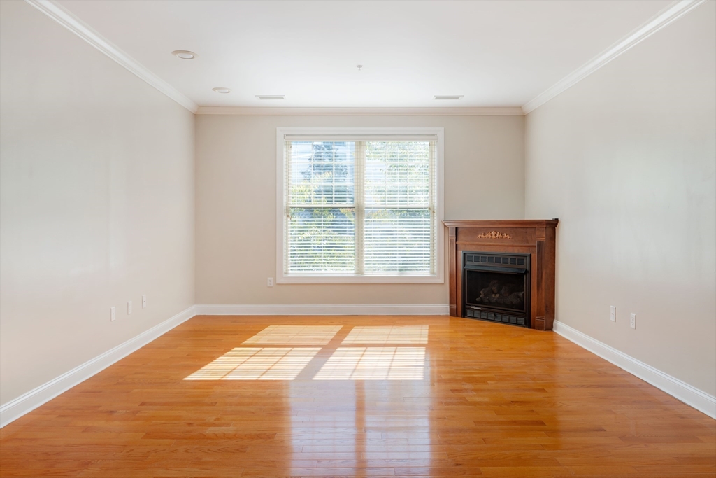 248 Albion Street, Unit 321 Wakefield, MA 01880 - Photo 6 of 19 a view of empty room with wooden floor and fireplace