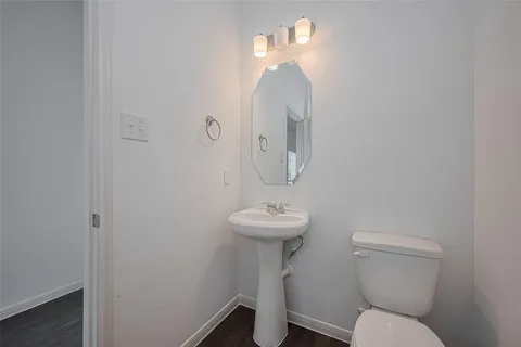 a bathroom with a toilet a sink and mirror
