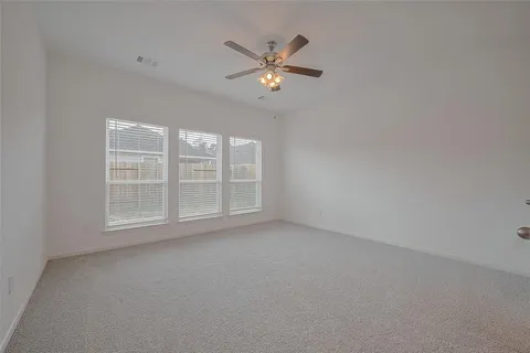 a view of an empty room and a ceiling fan