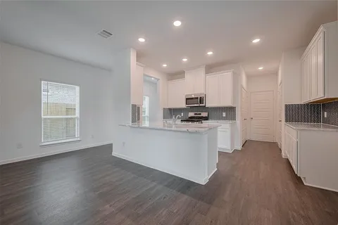a kitchen with white cabinets and appliances