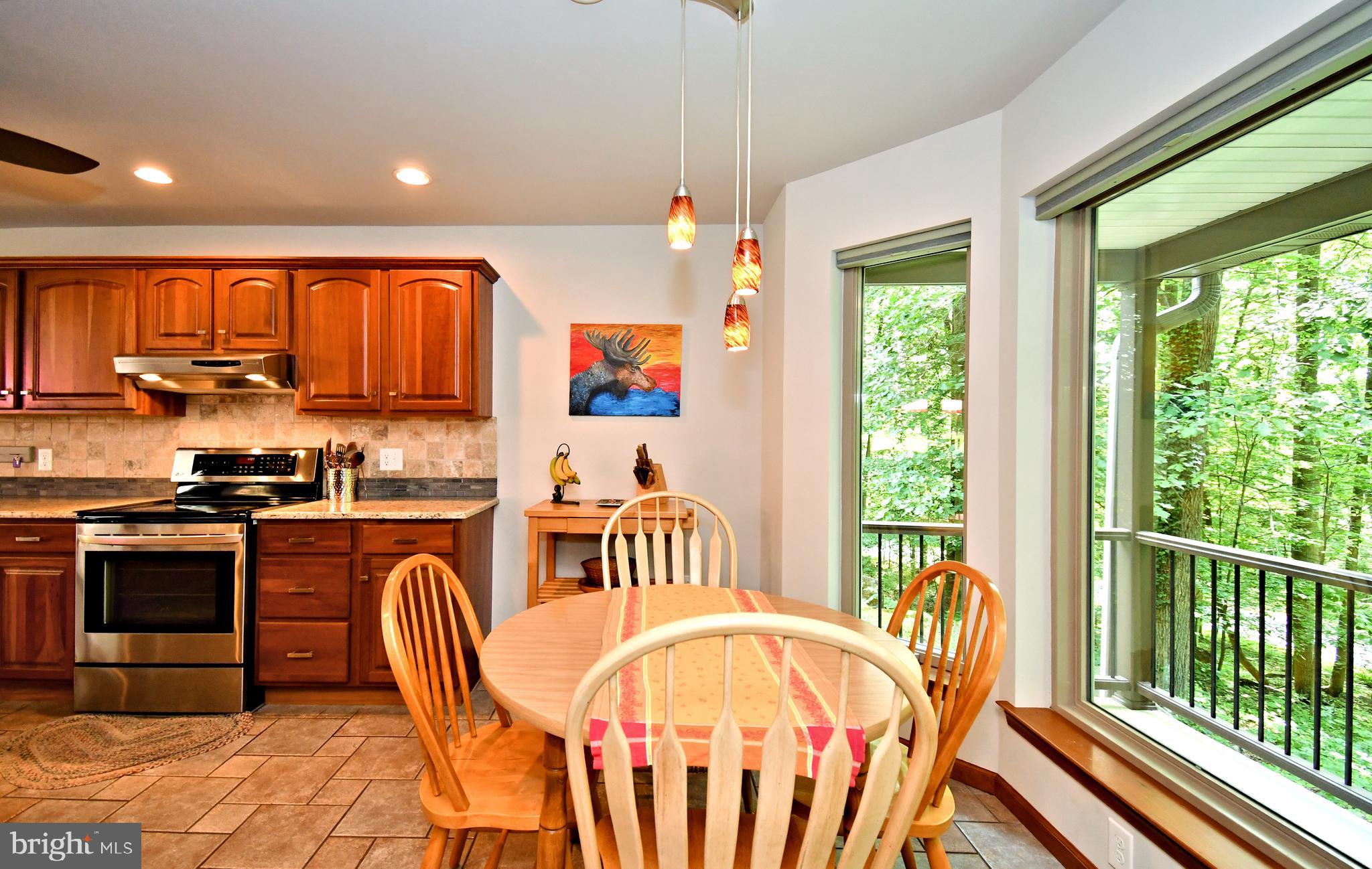 2415 Schaffer Road Pottstown, PA 19464 - Photo 14 of 93 a kitchen with stainless steel appliances granite countertop a stove a sink a kitchen island with chairs and wooden floor