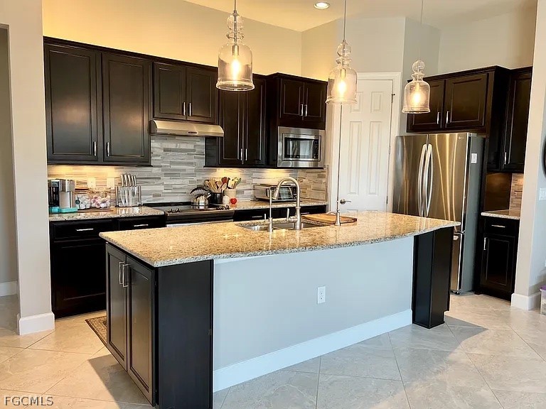 12804 Epping Way Fort Myers, FL 33913 - Photo 6 of 15 a kitchen with granite countertop stainless steel appliances and refrigerator