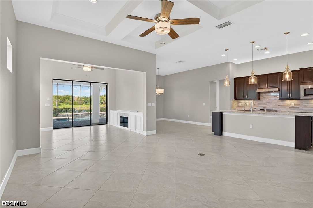 12804 Epping Way Fort Myers, FL 33913 - Photo 6 of 40 a view of an empty room with kitchen appliances and a ceiling fan