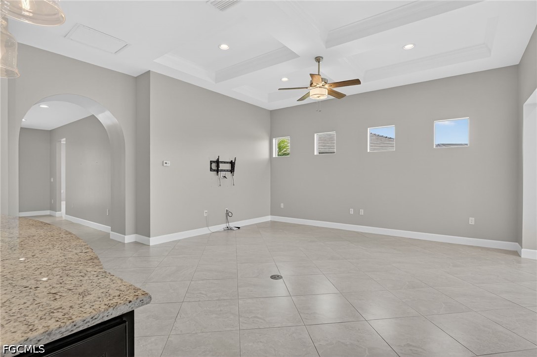 12804 Epping Way Fort Myers, FL 33913 - Photo 7 of 40 an empty room with chandelier fan and kitchen view