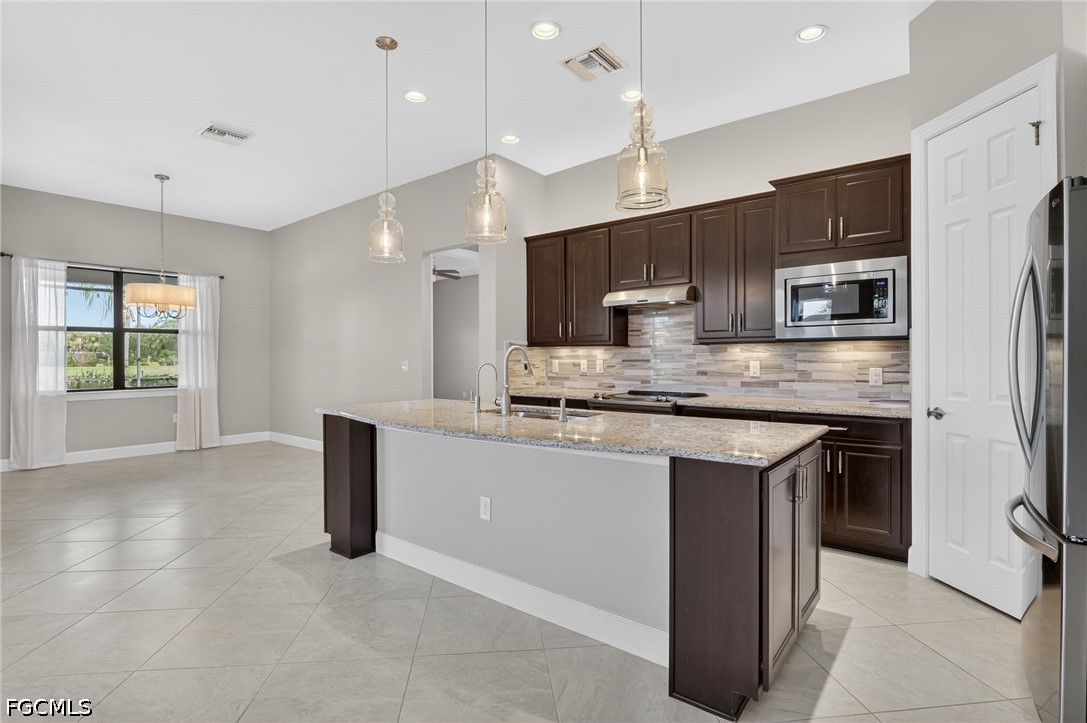 12804 Epping Way Fort Myers, FL 33913 - Photo 9 of 40 a large kitchen with kitchen island a large counter top space appliances and cabinets