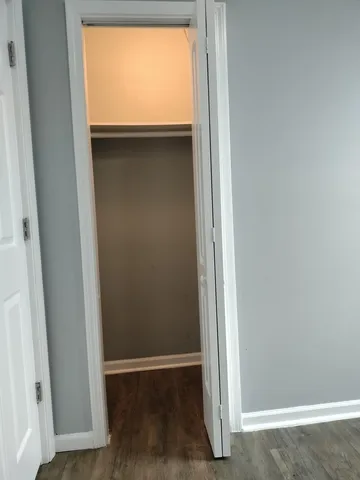 an empty room with wooden floor and entrance