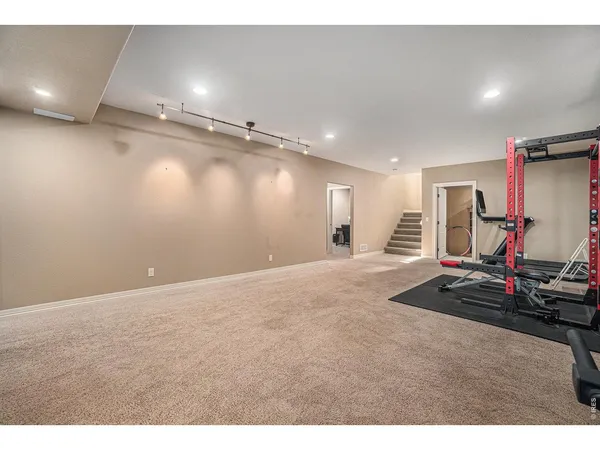 a living room with furniture a flat screen tv and gym equipment