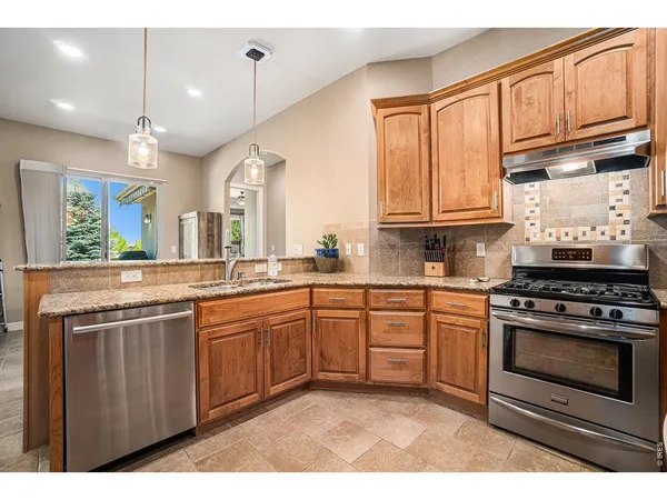 a kitchen with stainless steel appliances granite countertop a stove a sink and a microwave