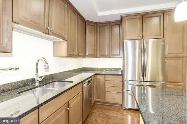 a kitchen with a refrigerator sink and cabinets