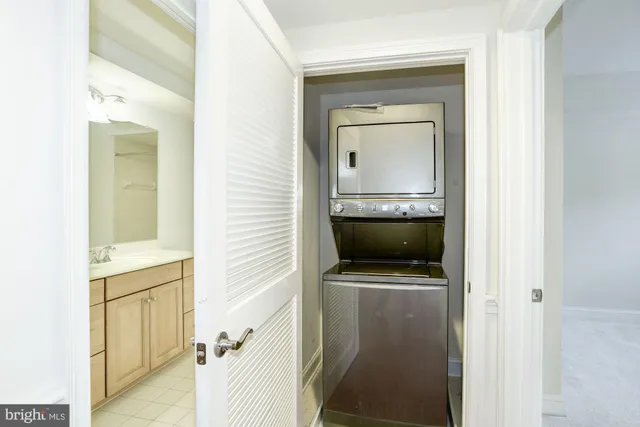a view of an empty room with closet and wooden door