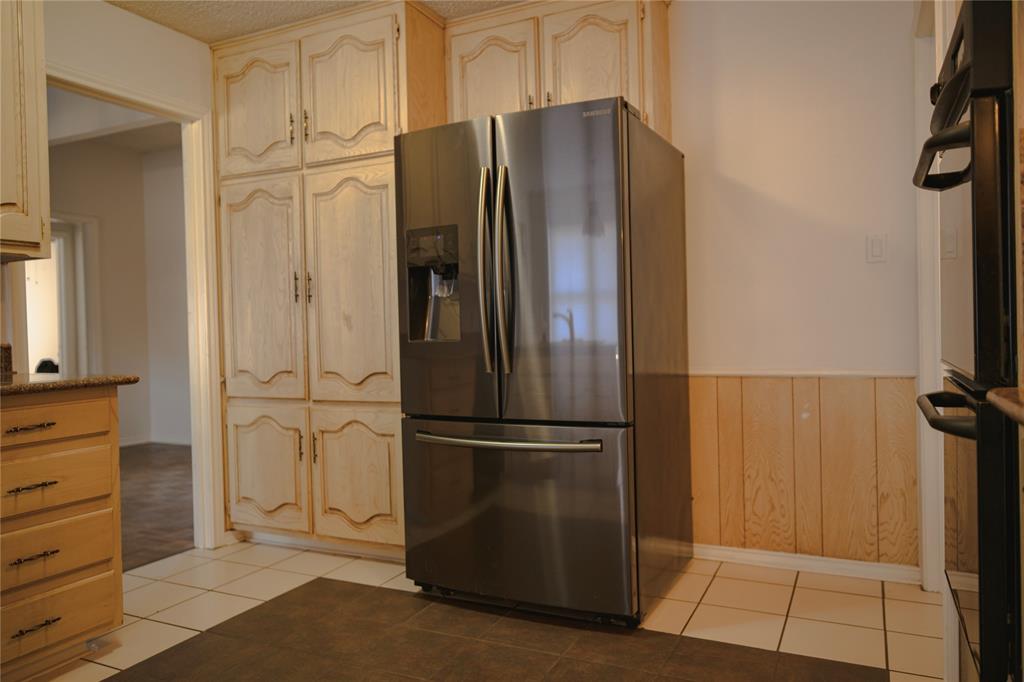 9029 Church Road Dallas, TX 75231 - Photo 11 of 40 a view of a refrigerator in kitchen and white cabinets