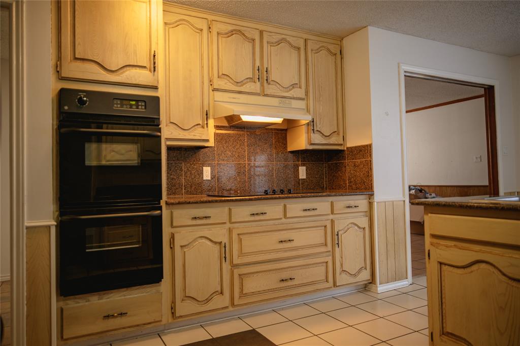 9029 Church Road Dallas, TX 75231 - Photo 14 of 40 a kitchen with granite countertop white cabinets and stainless steel appliances