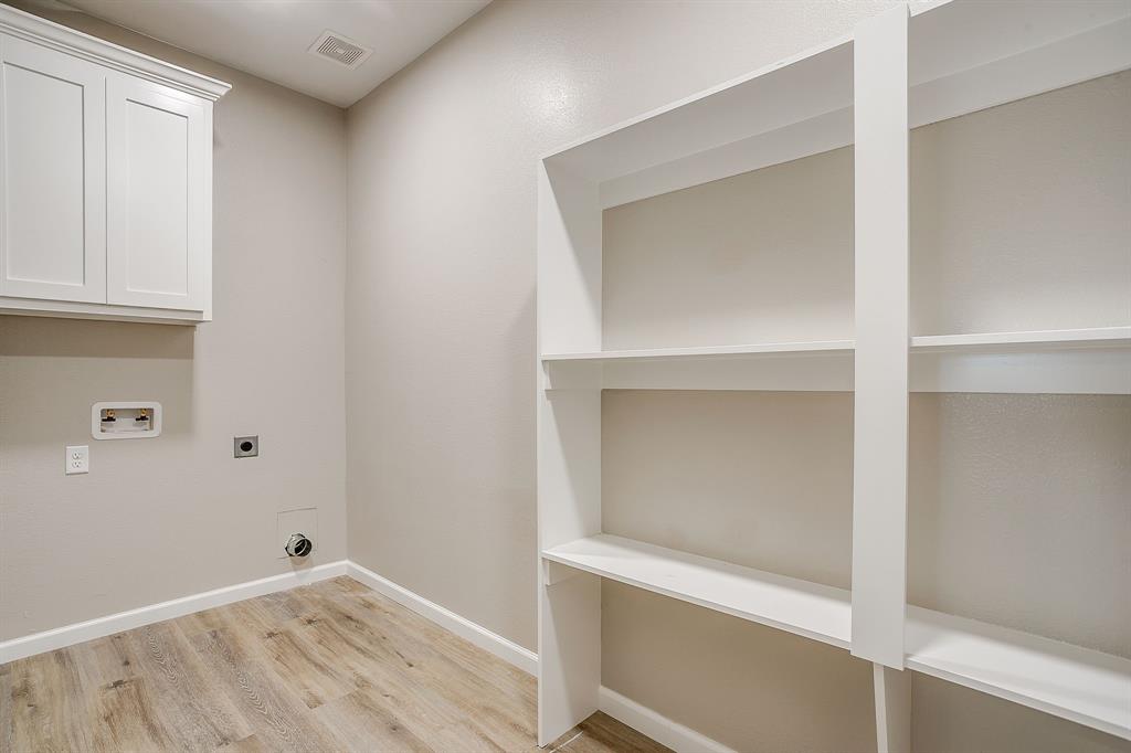 133 Winners Circle, Unit 302 Weatherford, TX 76087 - Photo 18 of 20 Washroom with electric dryer hookup, hookup for a washing machine, light wood finished floors, and cabinet space