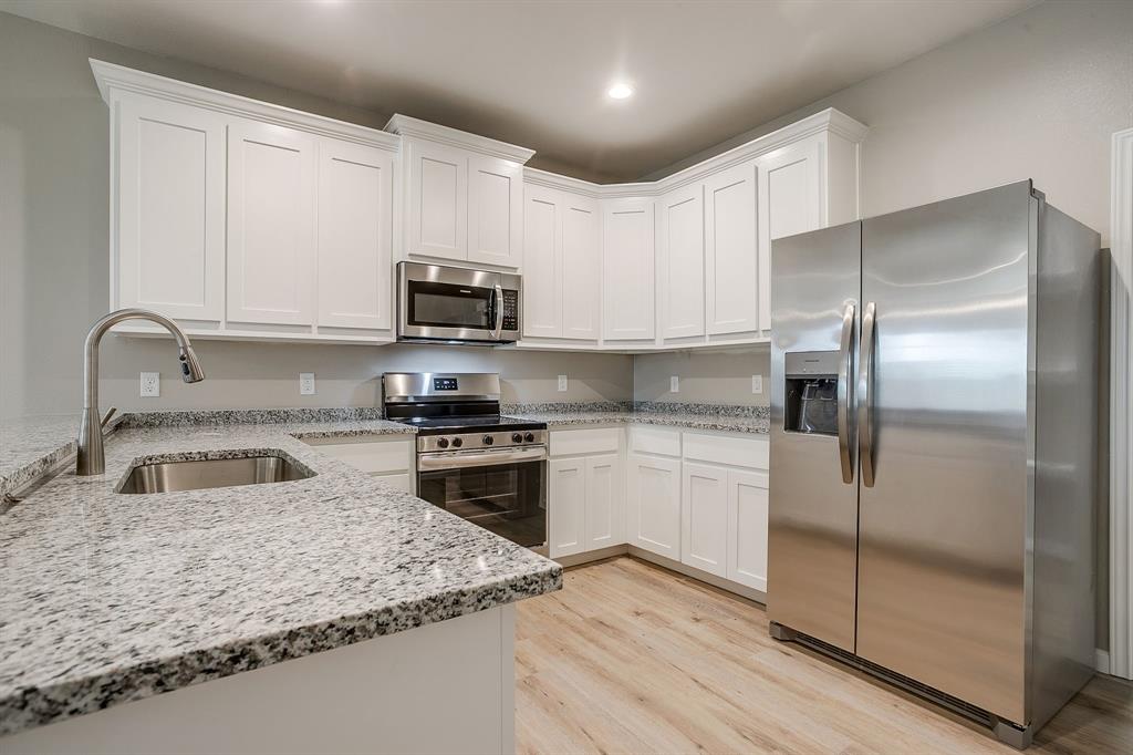 133 Winners Circle, Unit 302 Weatherford, TX 76087 - Photo 8 of 20 Kitchen with appliances with stainless steel finishes, light stone countertops, white cabinetry, light wood-style flooring, and recessed lighting