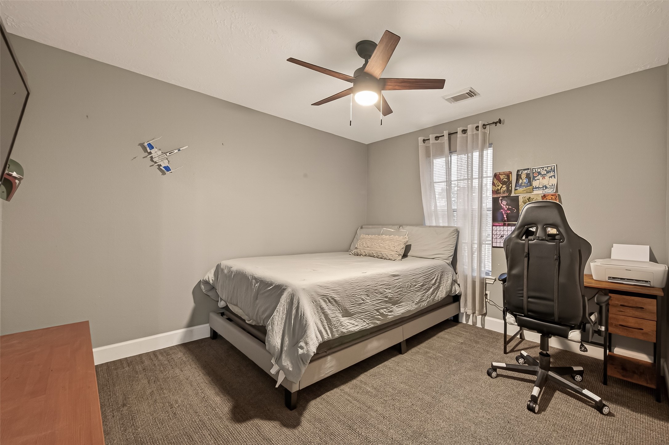 12206 Paddock Way Houston, TX 77065 - Photo 29 of 44 a bedroom with a bed a desk and chair with wooden floor
