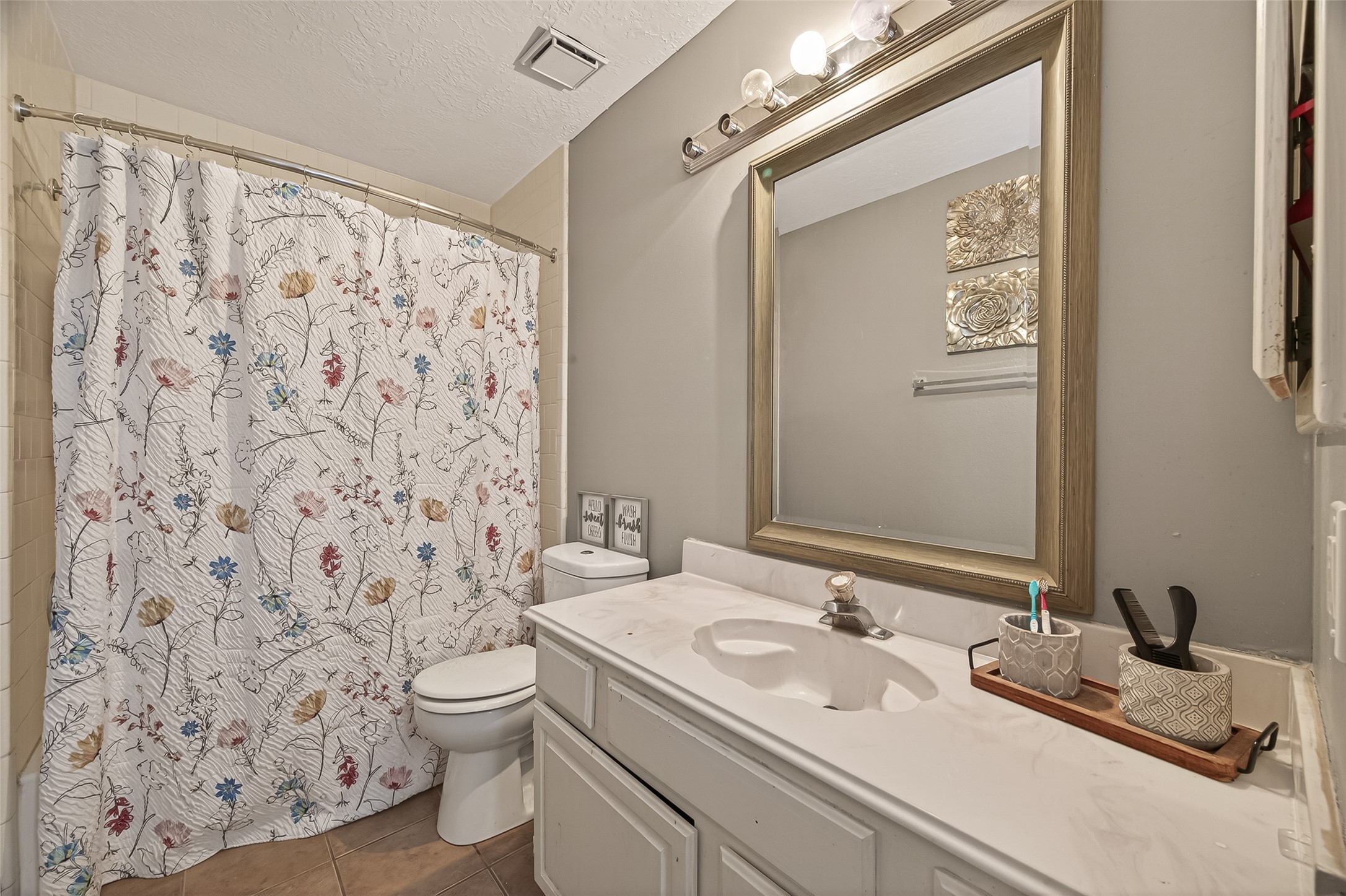 12206 Paddock Way Houston, TX 77065 - Photo 32 of 44 a bathroom with a granite countertop sink a toilet and a mirror