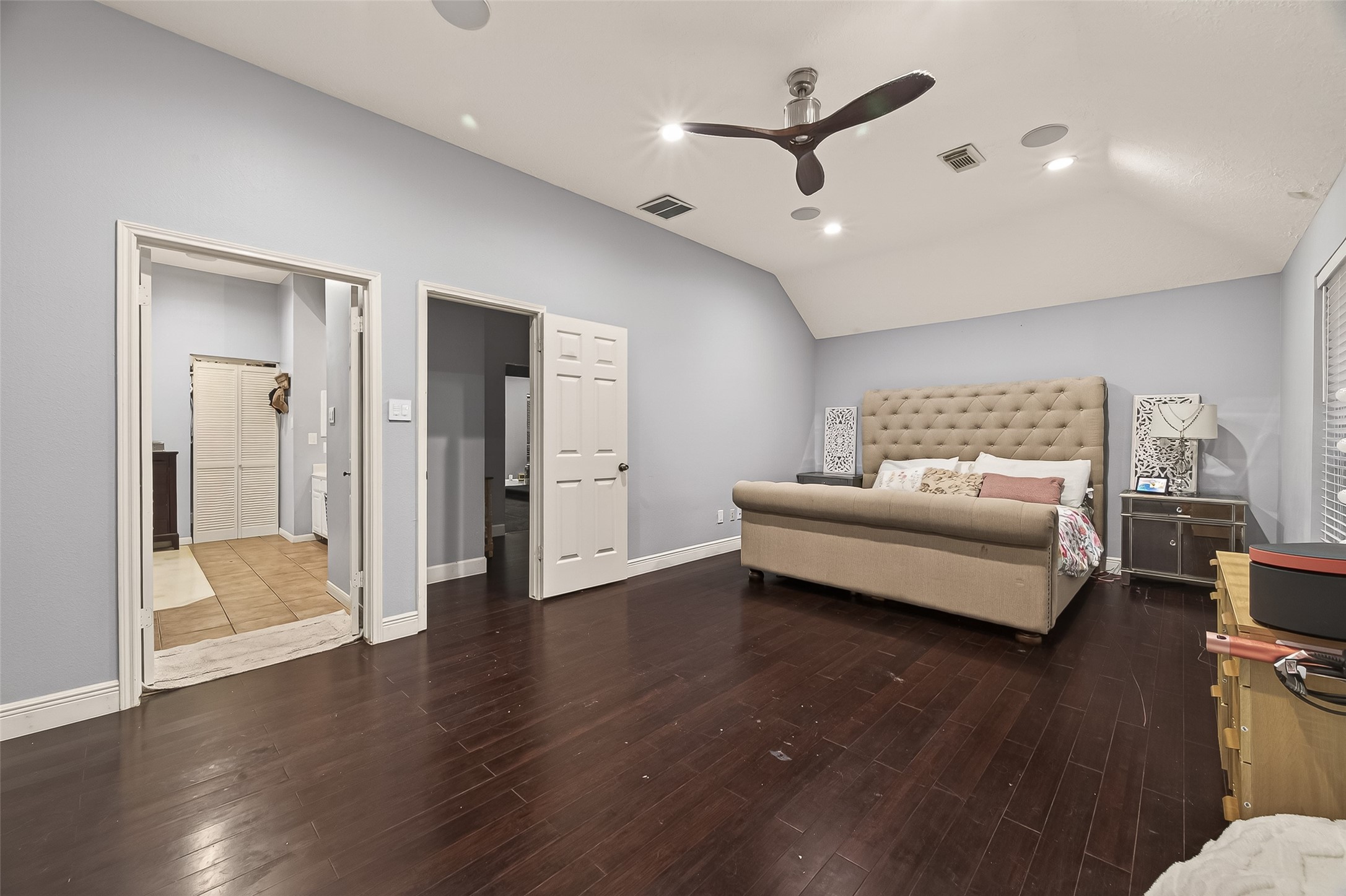 12206 Paddock Way Houston, TX 77065 - Photo 34 of 44 a spacious bedroom with bed and wooden floor