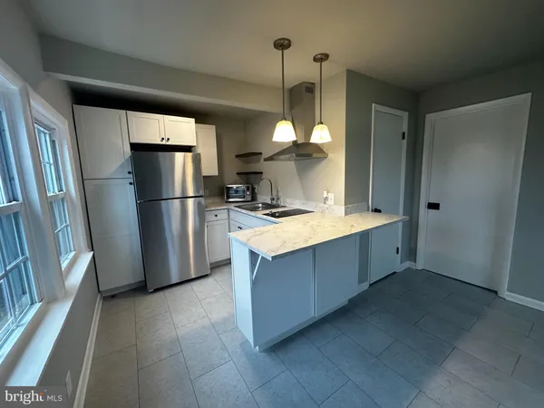 a kitchen with stainless steel appliances a stove a refrigerator a sink and cabinets