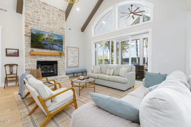 a living room with furniture large windows and wooden floor