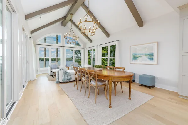 a large white kitchen with a large window and stainless steel appliances