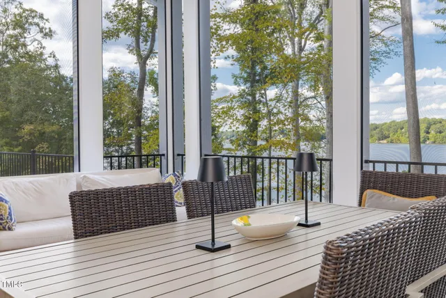 a living room with furniture a dining table chairs wooden floor and kitchen view