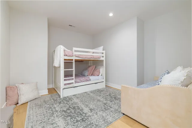 a view of a white house next to a yard with plants and trees