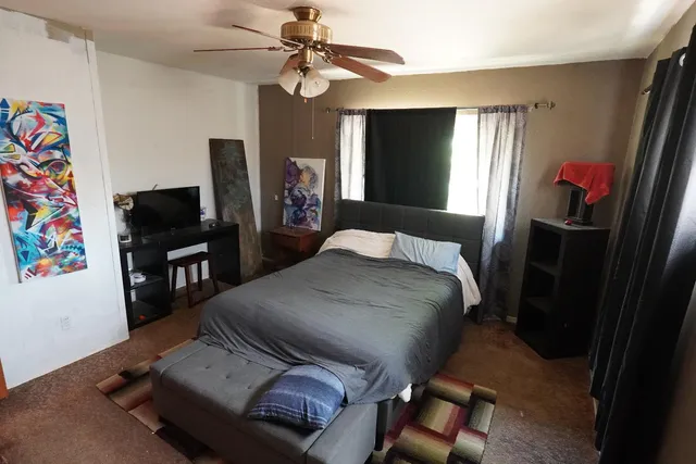a bedroom with a bed and a flat screen tv