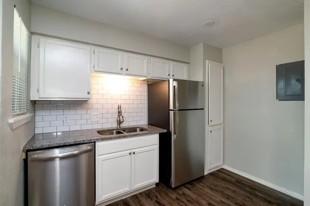 a kitchen with stainless steel appliances a refrigerator a sink and cabinets