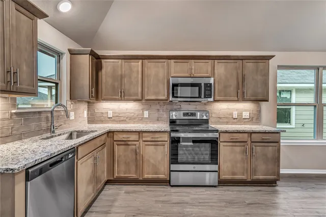 a kitchen with a sink stove top oven and microwave