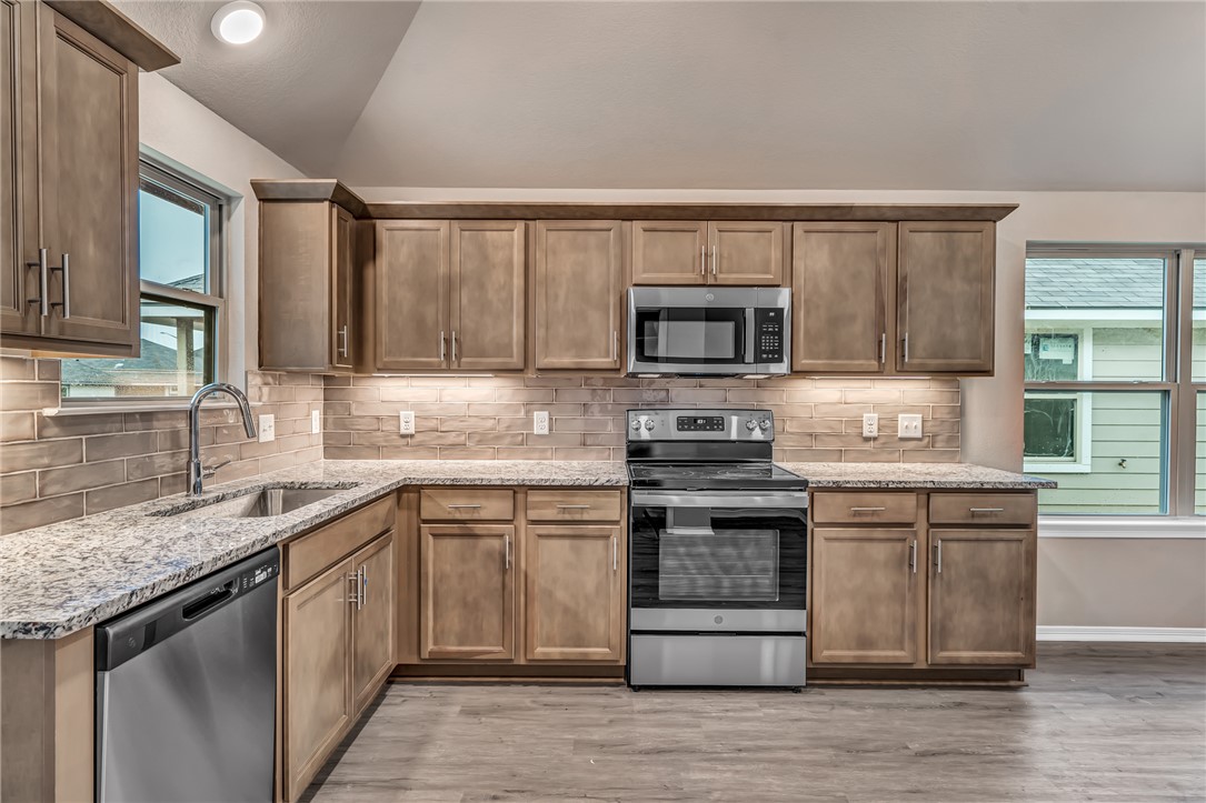 a kitchen with a sink stove top oven and microwave