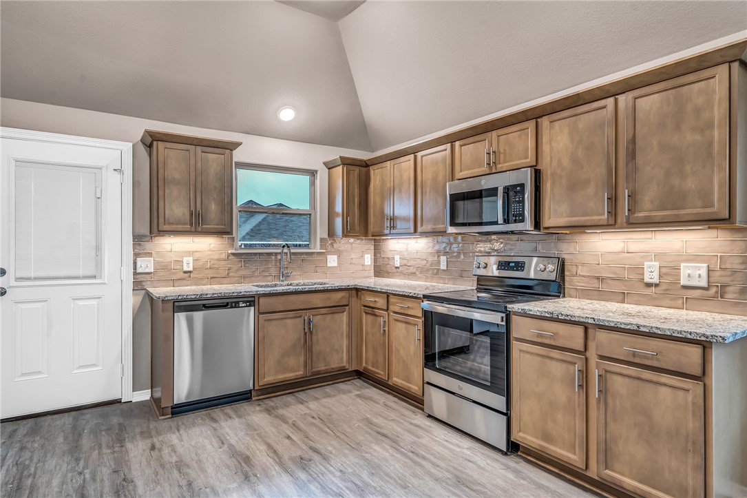 1218 High Street Navasota, TX 77868 - Photo 2 of 16 a kitchen with stainless steel appliances granite countertop a stove top oven a sink dishwasher and a microwave oven on the wooden floor