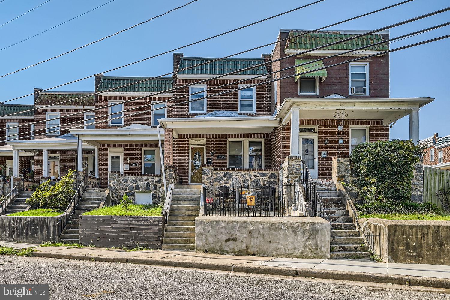1215 West Old Cold Spring Lane Baltimore, MD 21211 - Photo 2 of 33 front view of a brick house with a fountain